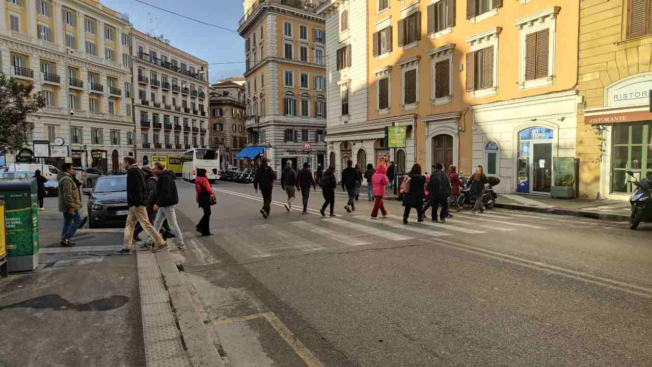 Pedoni attraversano la strada sulle strisce pedonali